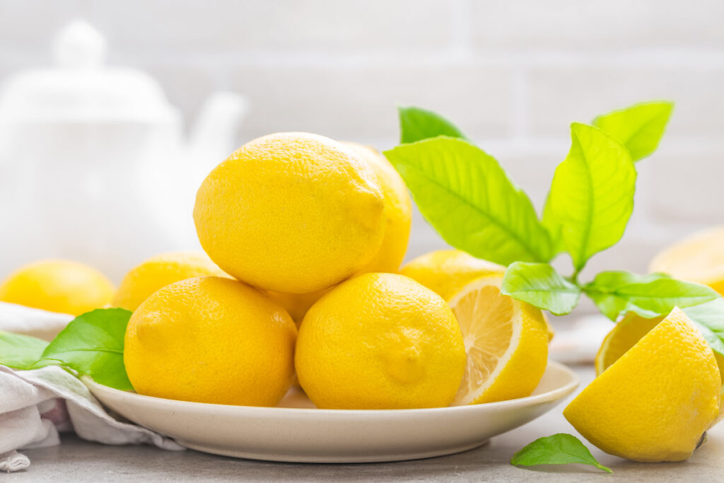 Fresh yellow lemons on a white plate