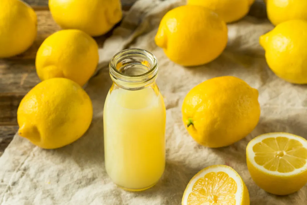 squeezed lemon juice in a glass bottle lemon fruit around it