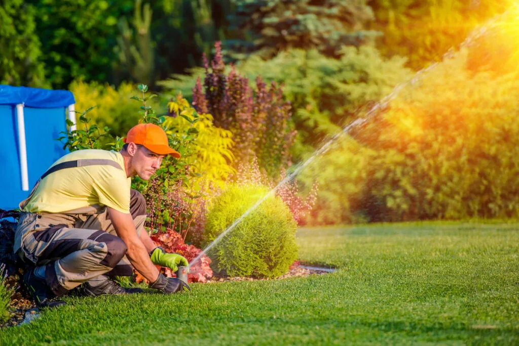 a man installing lawn water sprinkler in the yard 