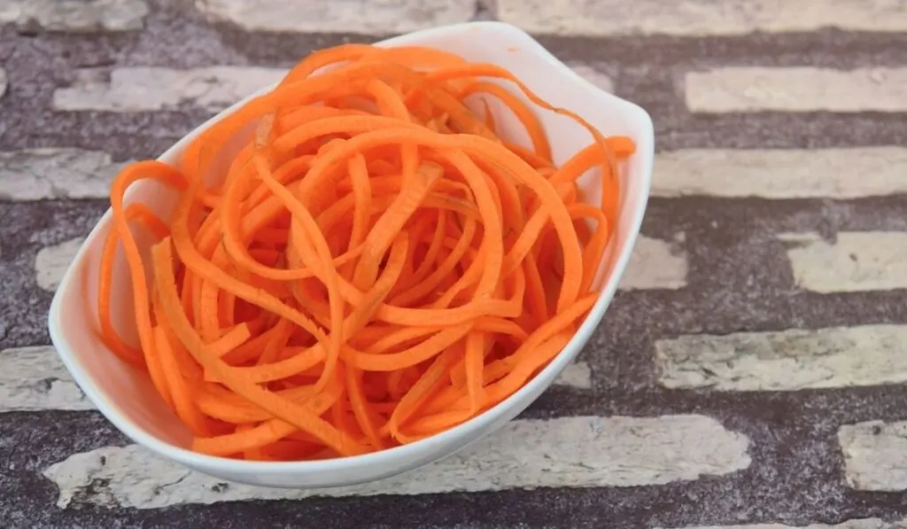 carrot noodles in a white bowl