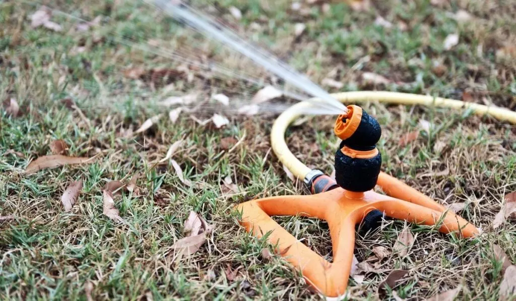 an orange garden hose sprinkler
