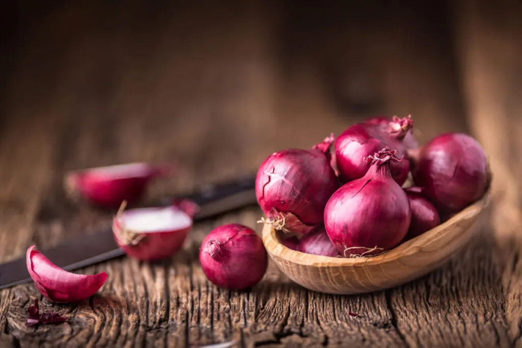 Red onions on a wood board