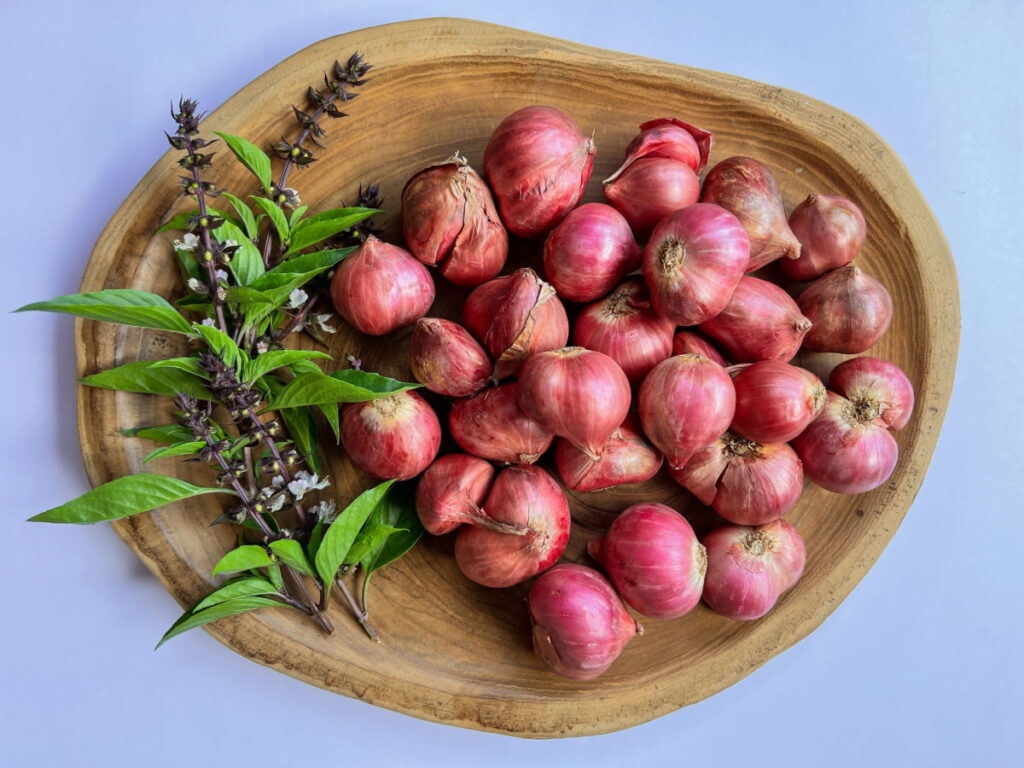 Red shallots on a wooden plate
