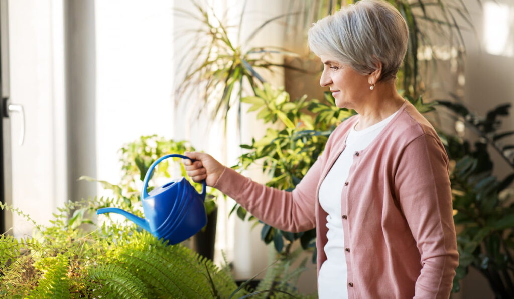 senior woman watering her plants at home