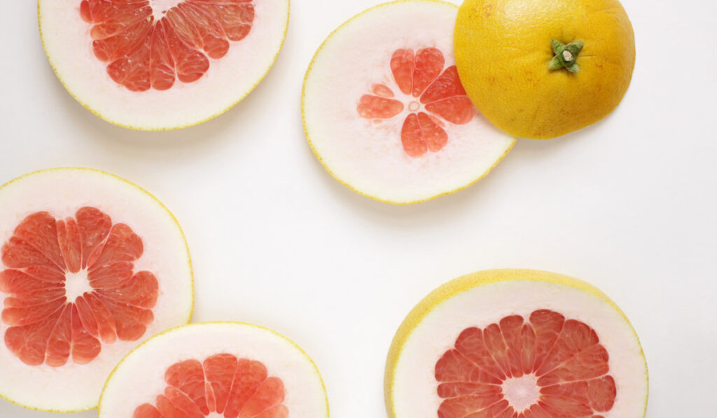 slices of pomelos on white background 
