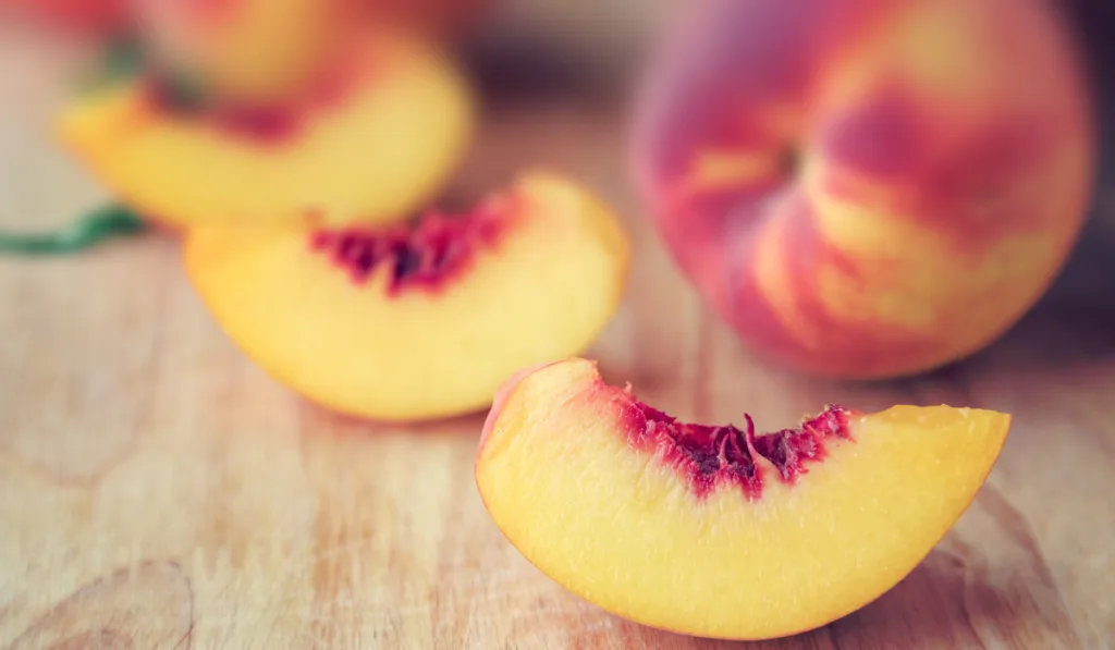 slices of peaches on a wooden board