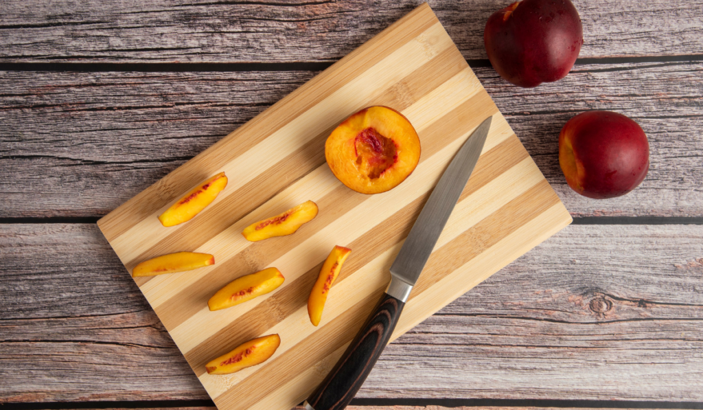 Top view of fresh peaches on cutting board