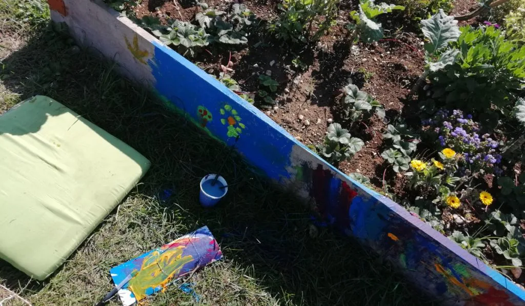childrens paintings on a raised bed garden
