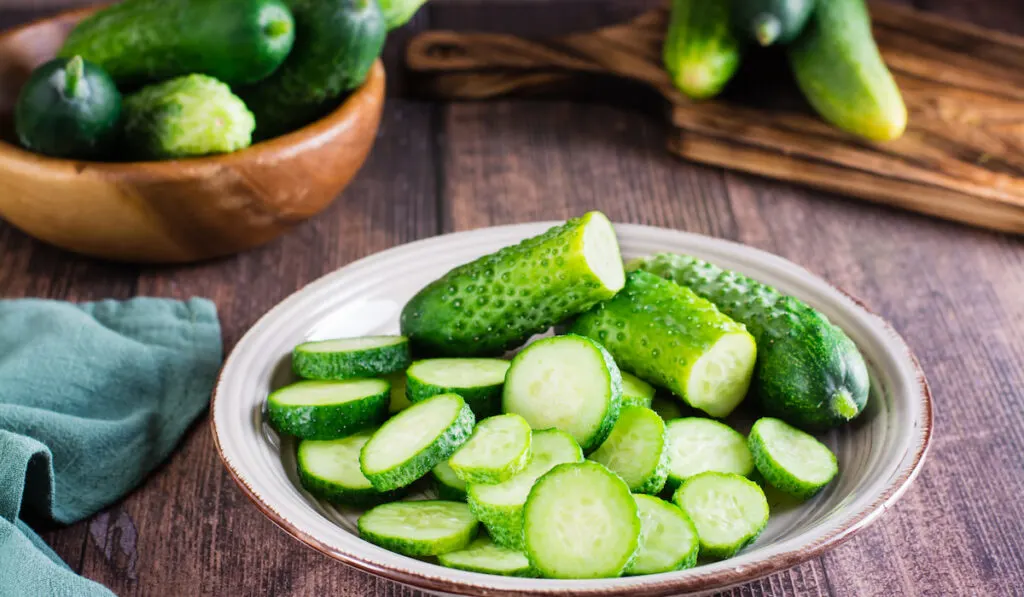 Fresh sliced cucumbers on a plate on a wooden table