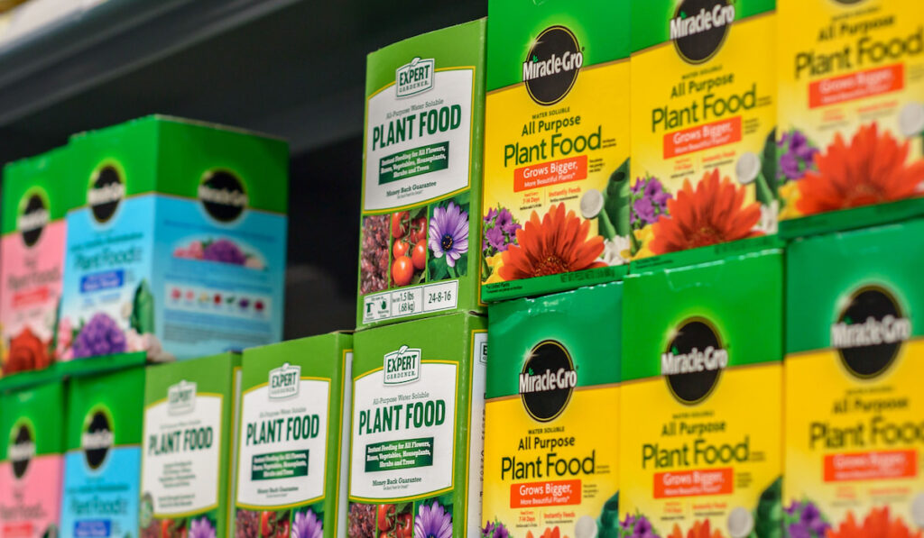 Miracle-gro plant food and other brands of vegetable and flower nutrients merchandised on a shelf at a supermarket