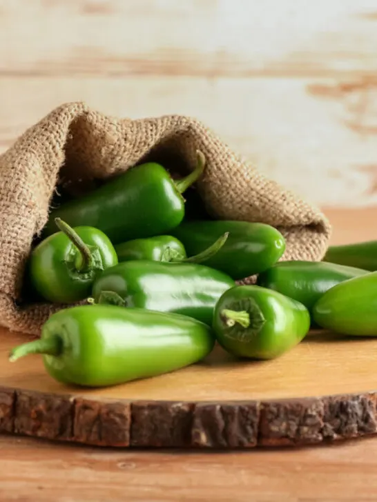 jalapeno peppers on a round wooden board