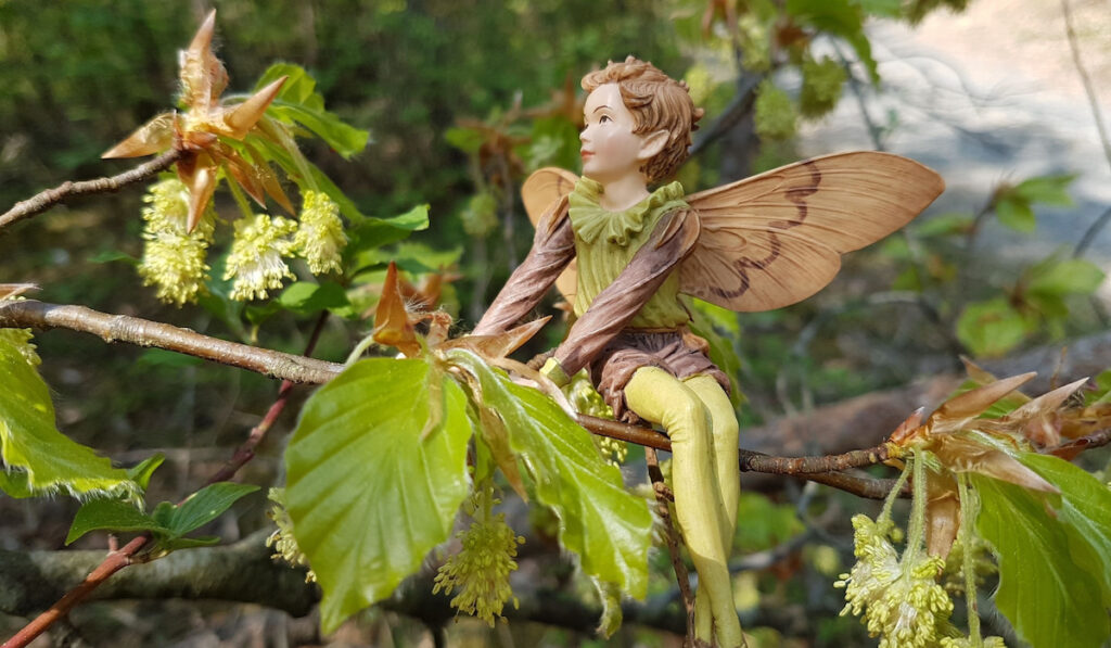 Cute fairy status on the tree twig in the garden