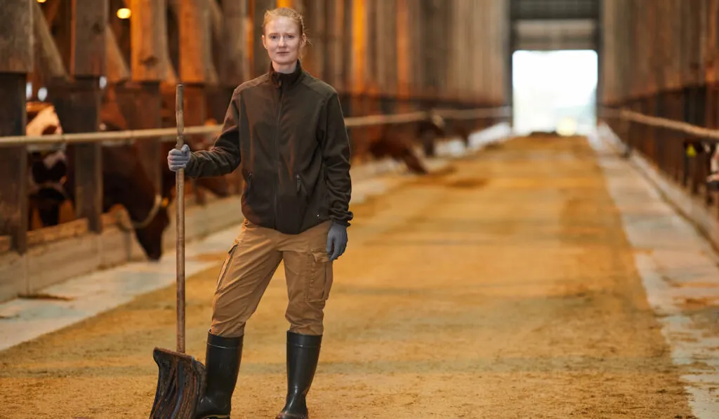 female worker holding shovel at farm
