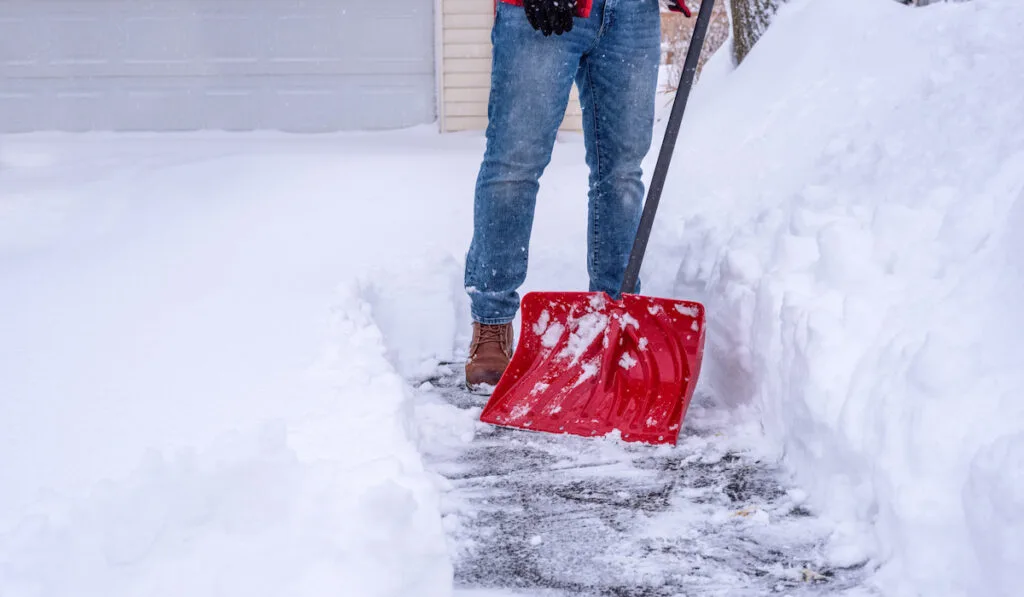 Man shoveling snow with Snow Shovel in front of the house