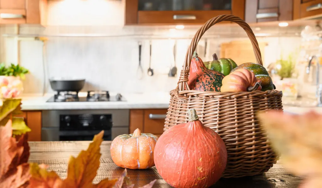 Cozy kitchen with pumpkins in a basket on the table