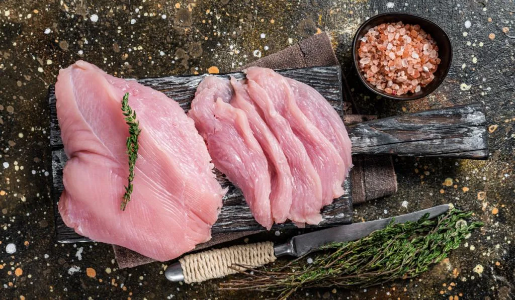 Raw turkey breast fillet meat on a cutting board