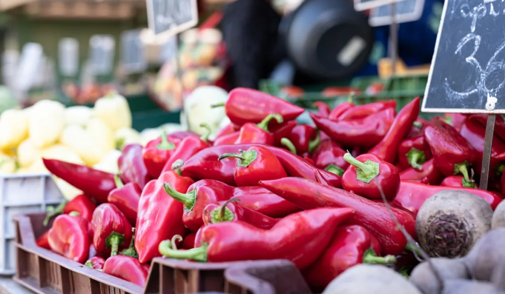 Closeup of fresh Piquillo peppers at an outdoor market
